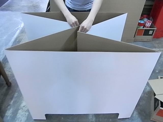 Holidaypac檔案參考資料，展示了人們組裝互鎖紙板托盤裙板隔板的過程。