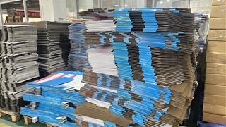 Stacks of blue printed and brown board components in the production area