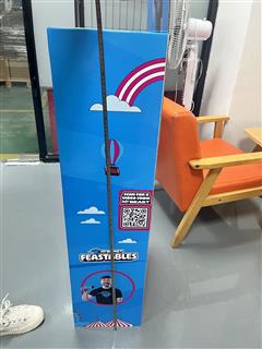 Side panel of a Feastables display with printed rainbow balloon graphics and QR code