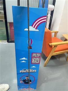 Side view of a Feastables cardboard display with a vertical ruler